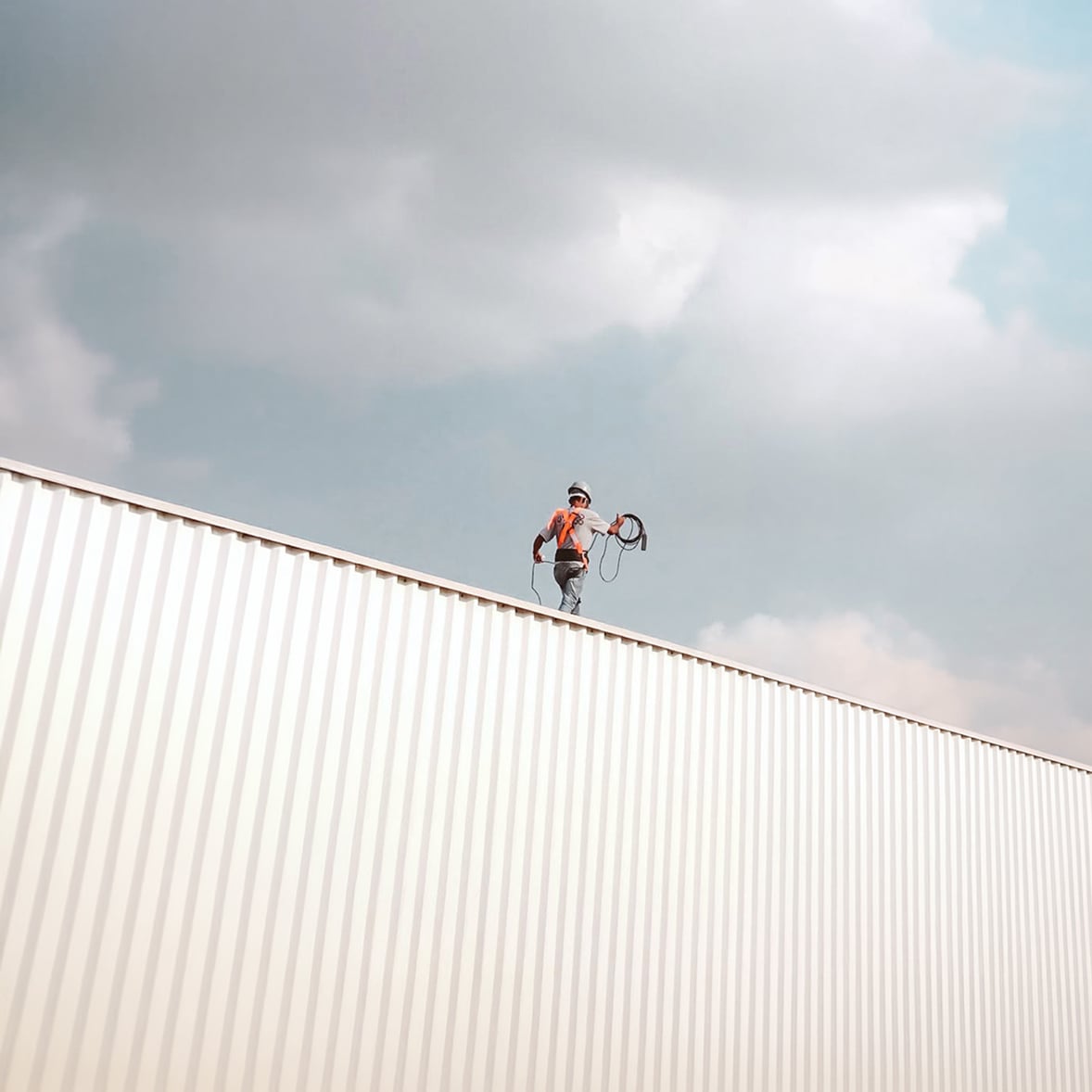 Construction worker in safety gear on roof
